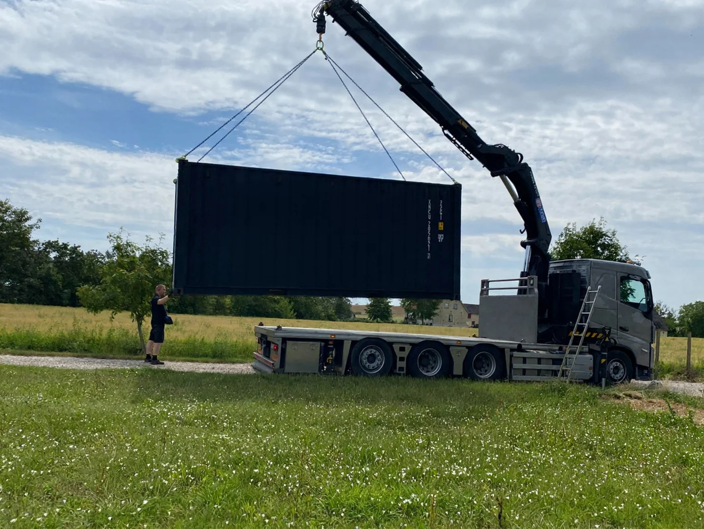 Kran-lastbil leverer container